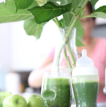 Green juice in a cup and baby bottle